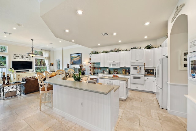 kitchen featuring white appliances, a spacious island, visible vents, and white cabinets