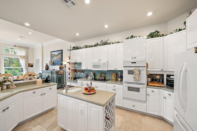 kitchen with white appliances, visible vents, light countertops, tasteful backsplash, and crown molding