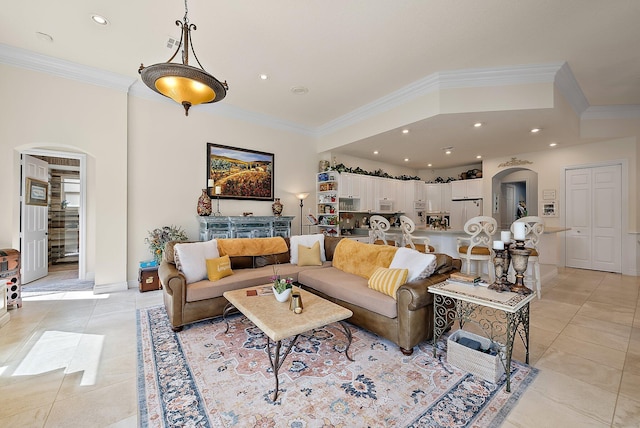 living area featuring ornamental molding, arched walkways, and light tile patterned floors