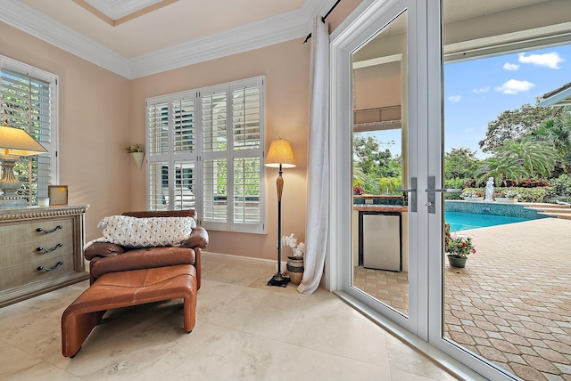 living area with baseboards, crown molding, and tile patterned floors