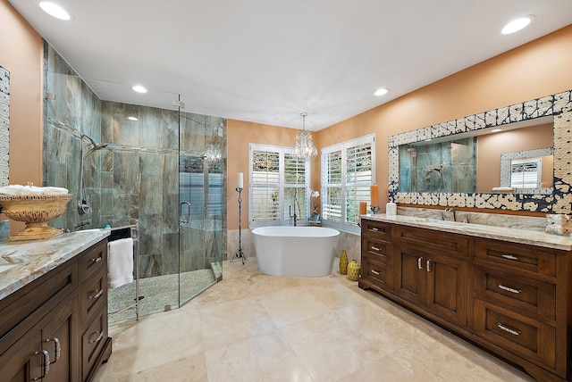 full bath featuring a stall shower, a soaking tub, vanity, a notable chandelier, and recessed lighting