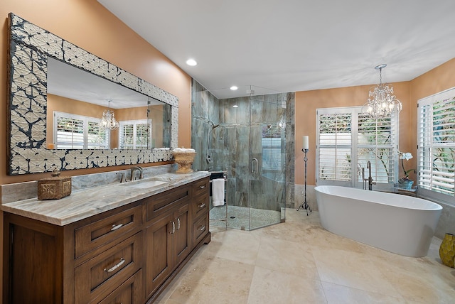 bathroom featuring a chandelier, a freestanding bath, a shower stall, and vanity