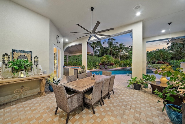 view of patio / terrace featuring outdoor dining area, a ceiling fan, and an outdoor pool