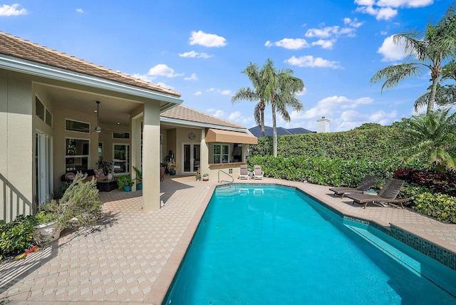 view of swimming pool featuring ceiling fan, a patio area, and a fenced in pool