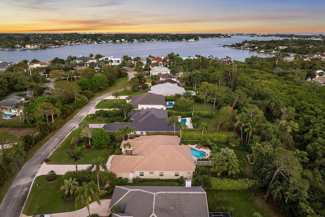 aerial view at dusk featuring a water view