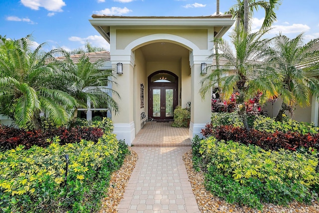 view of exterior entry with french doors and stucco siding