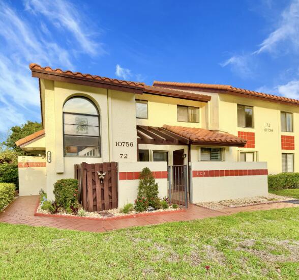 mediterranean / spanish home featuring a tiled roof, a front lawn, and stucco siding