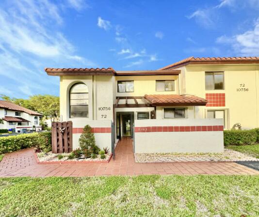 mediterranean / spanish house with a tiled roof and stucco siding