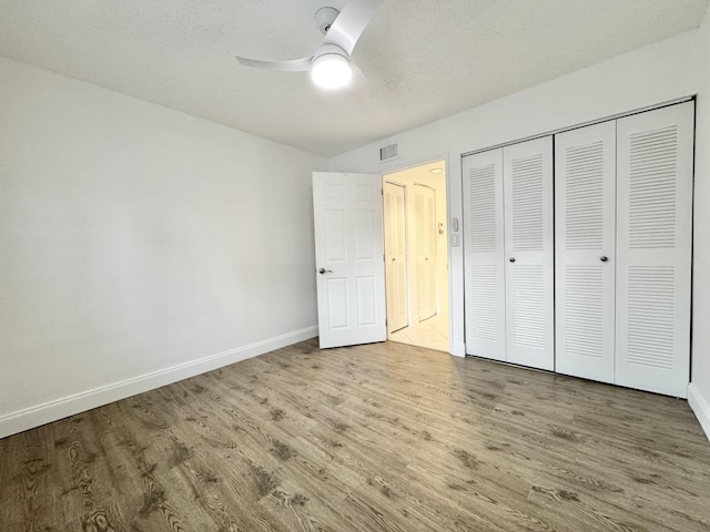 unfurnished bedroom featuring baseboards, visible vents, and wood finished floors