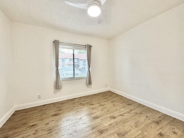 unfurnished room with a ceiling fan, a textured ceiling, baseboards, and wood finished floors