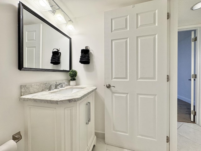 bathroom with tile patterned flooring, vanity, and baseboards