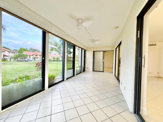 unfurnished sunroom with ceiling fan and visible vents