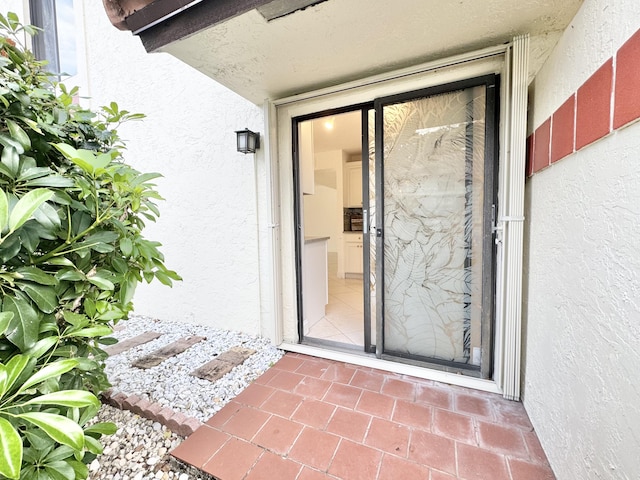 view of exterior entry with stucco siding