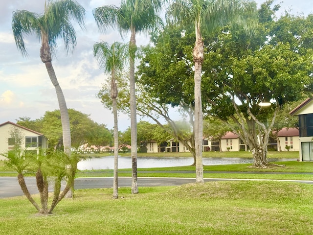 view of property's community featuring a water view and a lawn