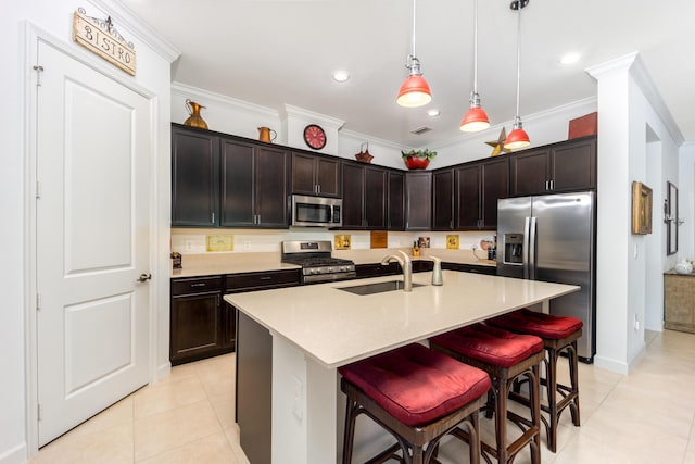 kitchen with a sink, a kitchen breakfast bar, stainless steel appliances, crown molding, and light tile patterned floors