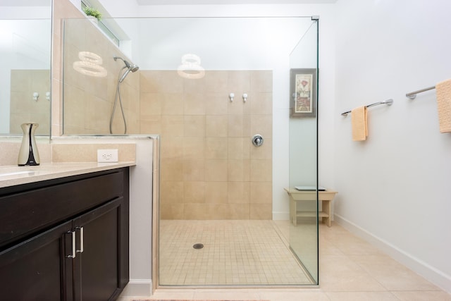 bathroom featuring vanity, tile patterned floors, baseboards, and walk in shower