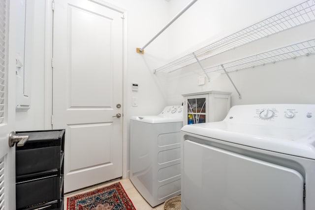 laundry room with laundry area, light tile patterned floors, and washer and clothes dryer