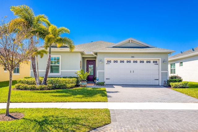 ranch-style house with decorative driveway, a front lawn, an attached garage, and stucco siding