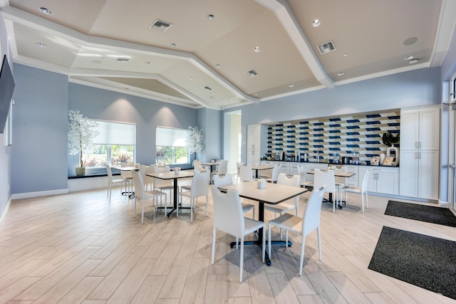 dining area with visible vents, light wood-style floors, and high vaulted ceiling