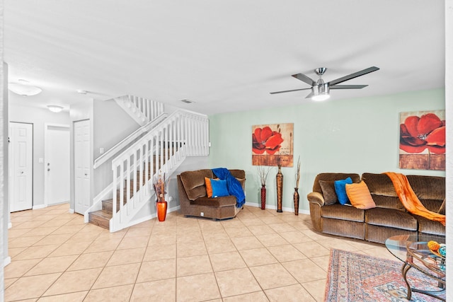 living room with light tile patterned floors, visible vents, a ceiling fan, baseboards, and stairs