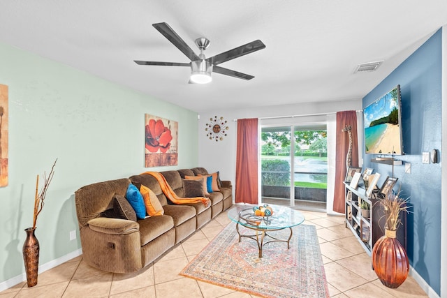 living area with light tile patterned floors, ceiling fan, visible vents, and baseboards