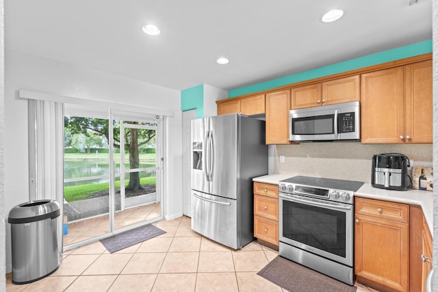 kitchen featuring light tile patterned floors, recessed lighting, stainless steel appliances, light countertops, and backsplash