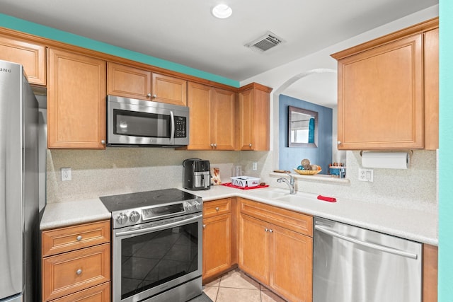 kitchen with visible vents, stainless steel appliances, light countertops, backsplash, and light tile patterned flooring