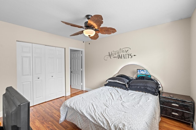 bedroom with a closet, ceiling fan, baseboards, and wood finished floors