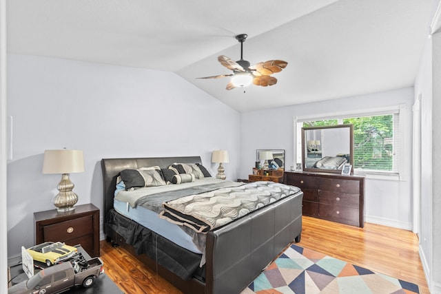 bedroom with lofted ceiling, baseboards, a ceiling fan, and light wood-style floors