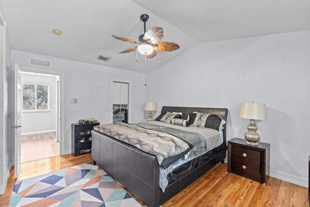 bedroom with vaulted ceiling, a closet, light wood-type flooring, and visible vents