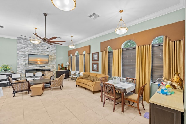 dining area with light tile patterned floors, a fireplace, visible vents, a ceiling fan, and ornamental molding