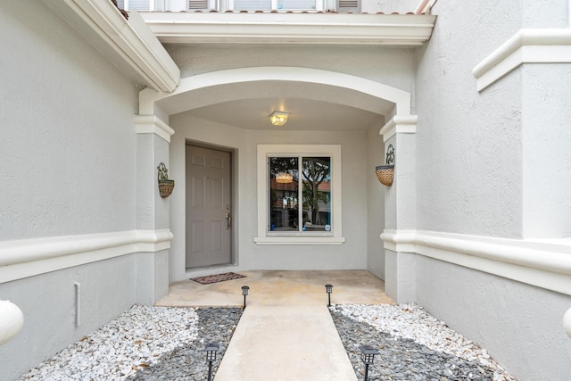 doorway to property featuring stucco siding