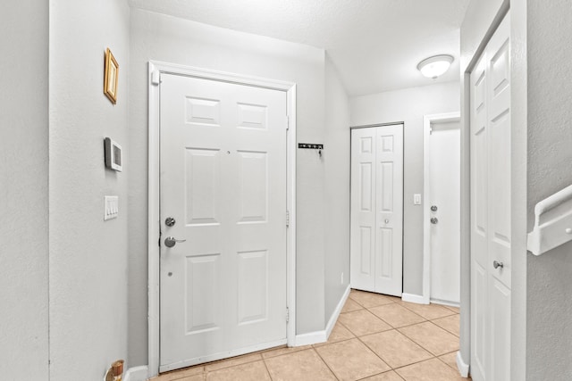 interior space featuring light tile patterned floors and baseboards