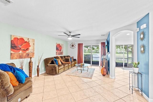 living room with light tile patterned floors, baseboards, visible vents, and ceiling fan