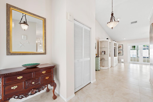 corridor featuring visible vents, baseboards, and lofted ceiling