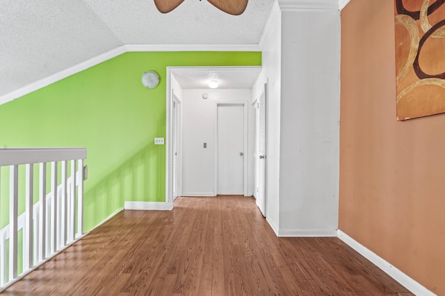 bonus room with lofted ceiling, a ceiling fan, a textured ceiling, wood finished floors, and baseboards