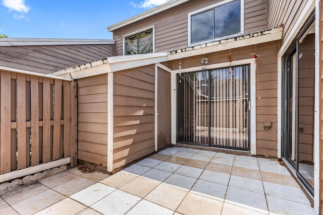 view of exterior entry with a patio area