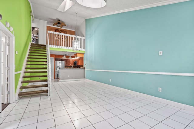 unfurnished living room with stairway, a skylight, ornamental molding, and tile patterned floors