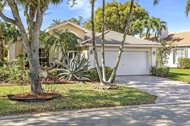 view of front facade with a garage, a tile roof, decorative driveway, stucco siding, and a chimney