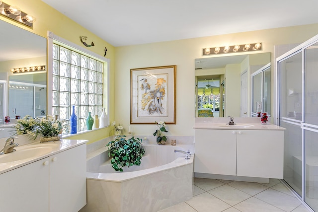 full bath featuring two vanities, a sink, a shower stall, a bath, and tile patterned floors