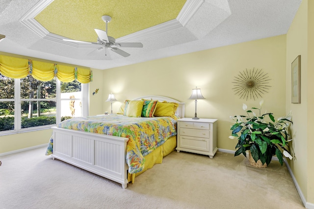 bedroom featuring baseboards, a tray ceiling, a textured ceiling, and light colored carpet