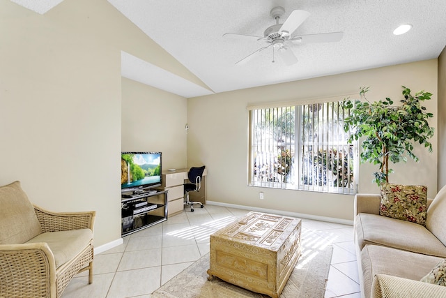 living area featuring light tile patterned floors, lofted ceiling, ceiling fan, a textured ceiling, and baseboards