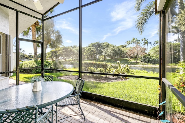 unfurnished sunroom with a water view and ceiling fan