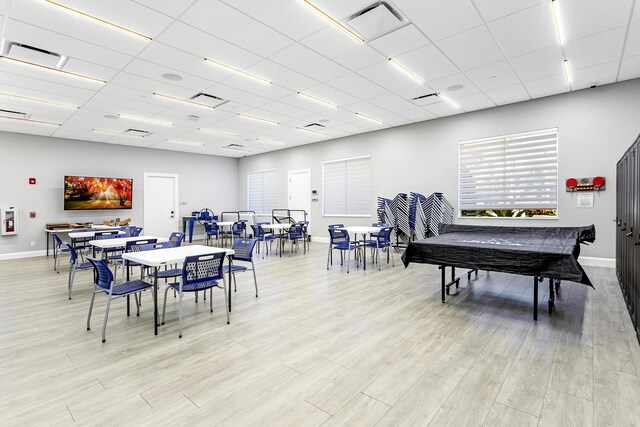 dining space with a paneled ceiling, visible vents, and light wood-style floors