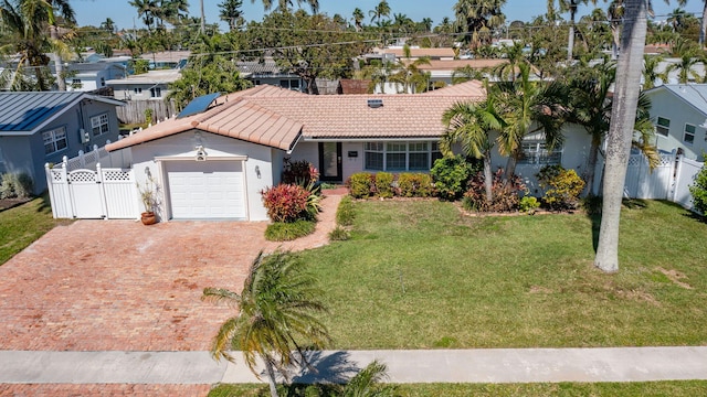 single story home with a garage, a tile roof, decorative driveway, a gate, and a front yard