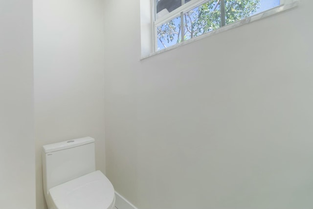 bathroom featuring toilet and baseboards