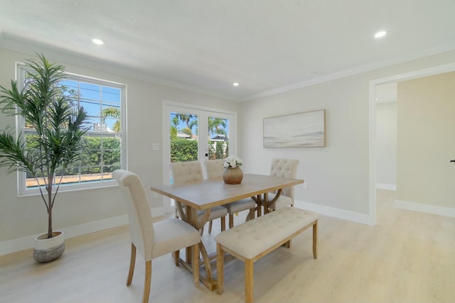 dining room with light wood-style floors, baseboards, and ornamental molding