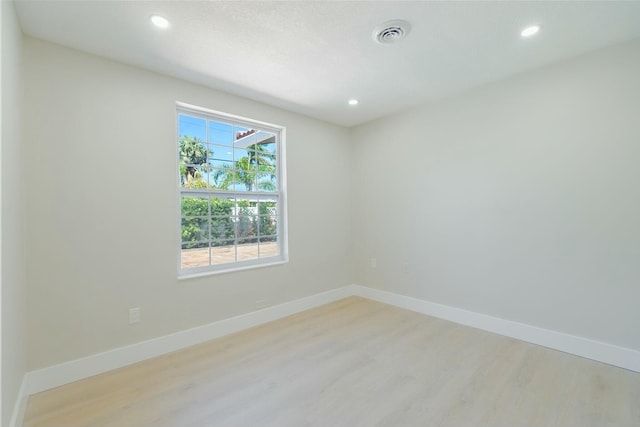 unfurnished room featuring light wood-style floors, recessed lighting, visible vents, and baseboards