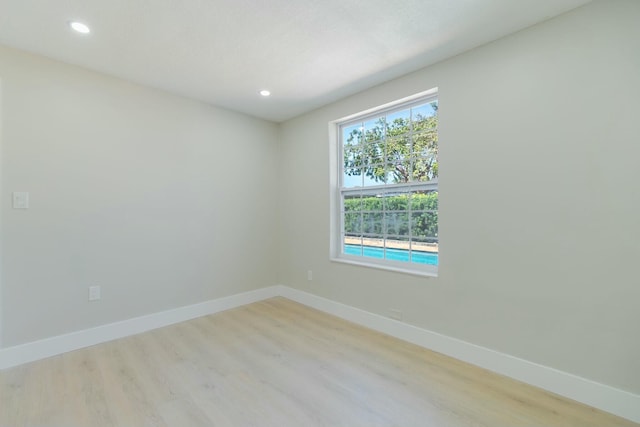 unfurnished room featuring light wood-type flooring, baseboards, and recessed lighting