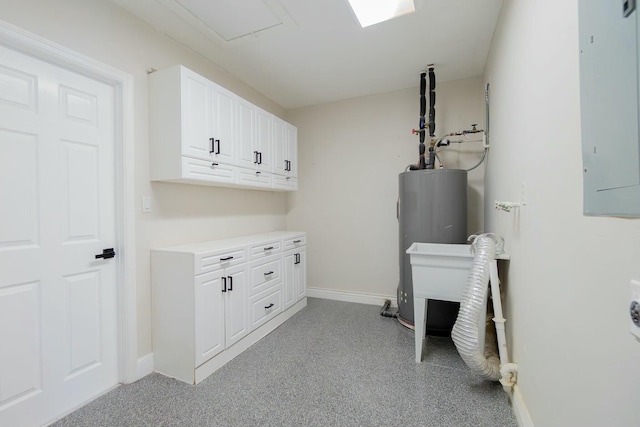 washroom featuring electric panel, cabinet space, baseboards, and electric water heater